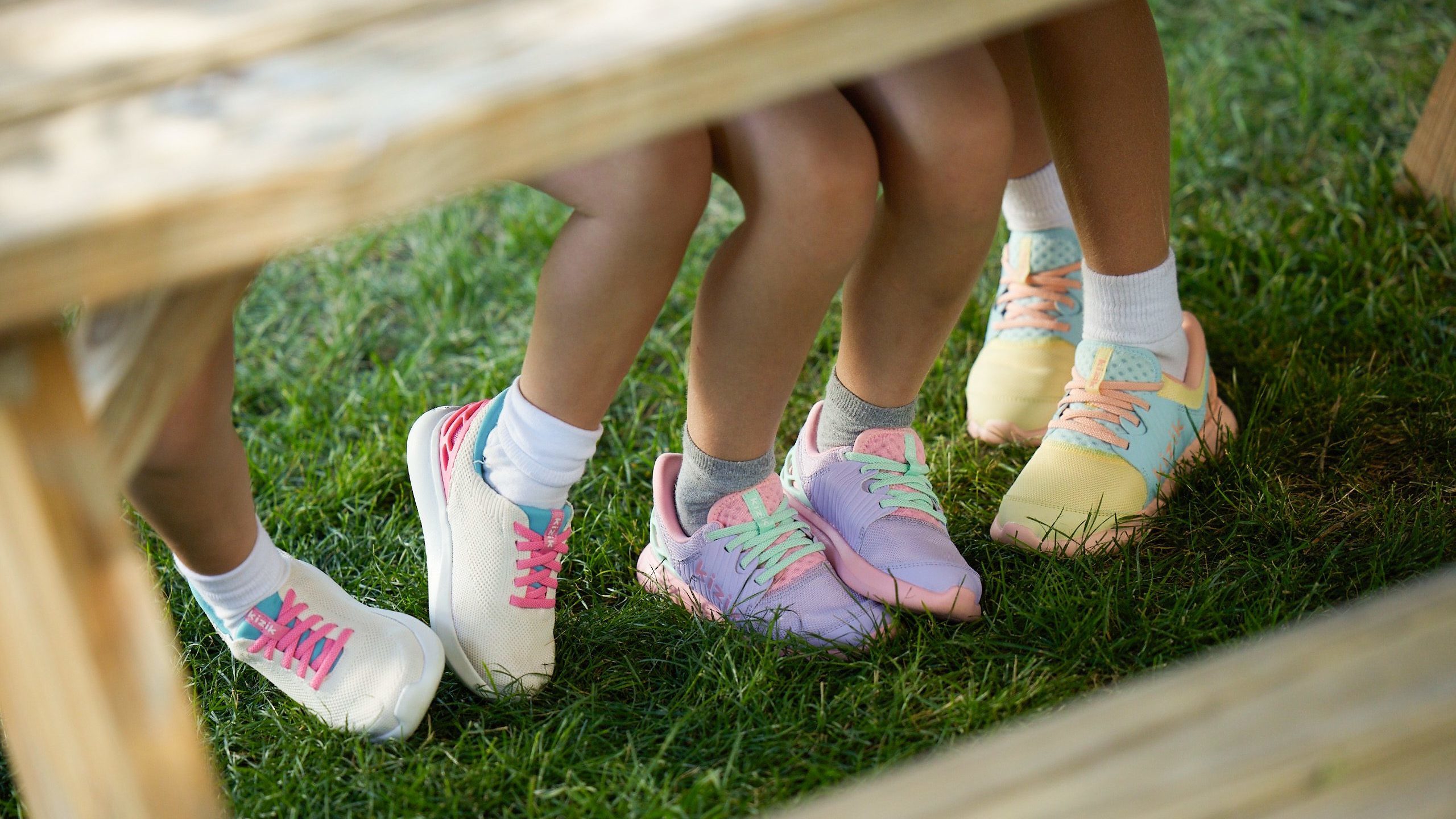 Visual of kids sitting at a picnic table wearing Kizik's new line of kid's sneakers.