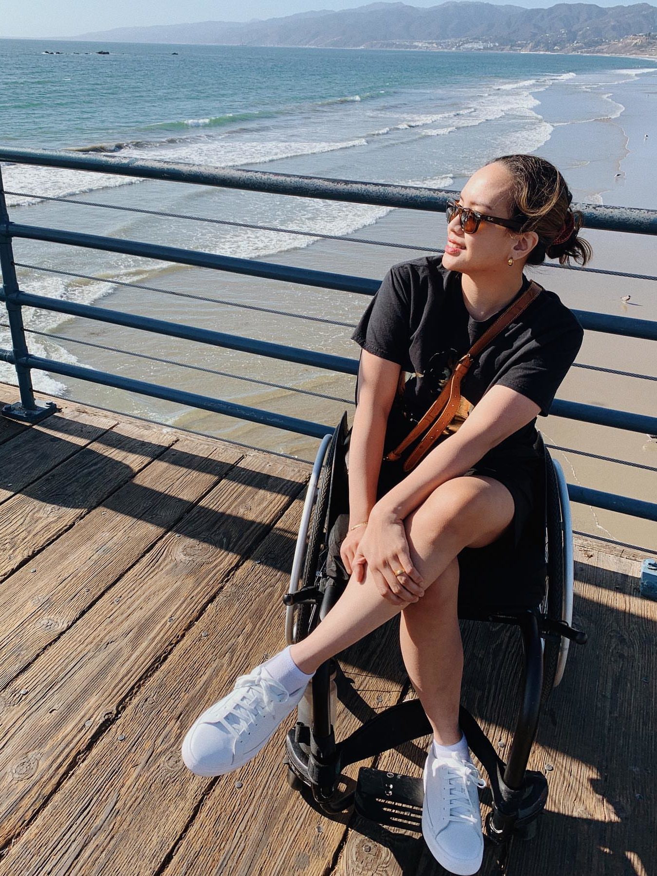 Image of digital creator, Kimy City, a SCI survivor, in her wheelchair on a boardwalk in California wearing Kizik sneakers.