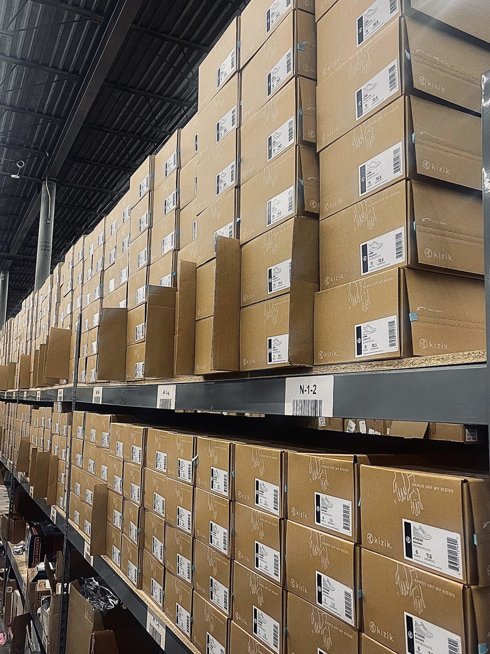 Visual of Kizik shoe boxes organized on shelves at a Deliverr cross-dock.